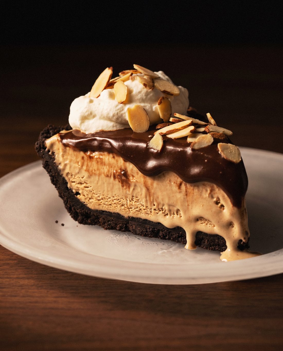 Mud pie with coffee ice cream, fudge, whipped cream and almonds